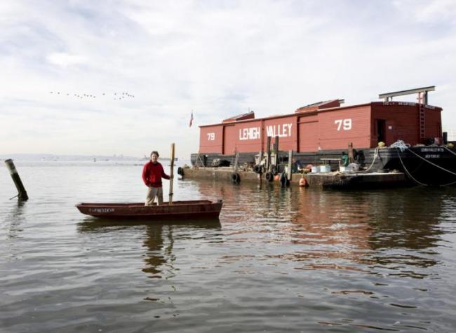 David in a skiff near the barge