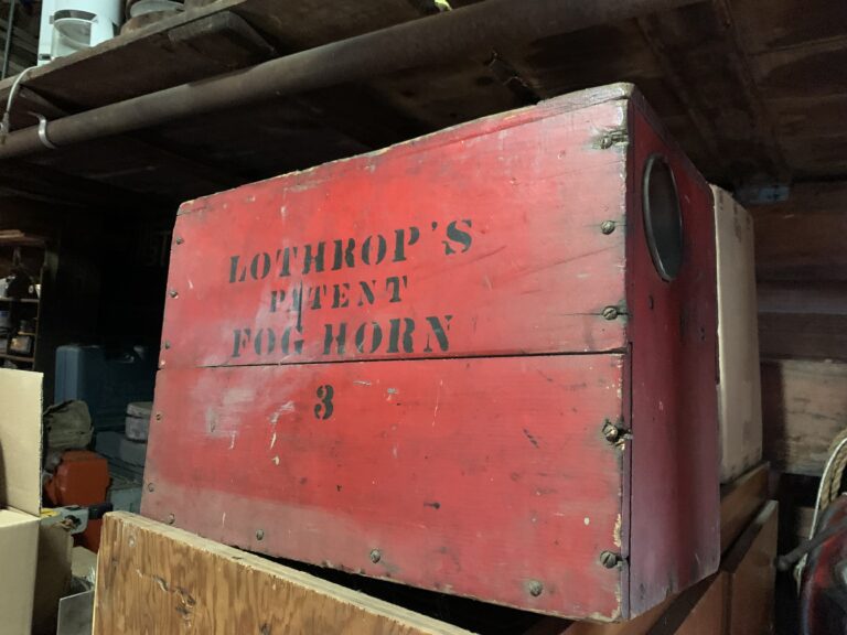 red wooden box with a screen hole on a short side labeled in black Lothrop's Patent Fog Horn 3